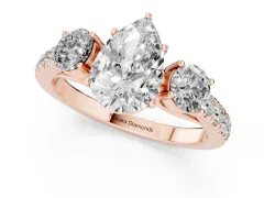 Pear Cut Diamond Three-Stone Ring Set in Rose gold with Round Side Stones and Delicate Pavé Band