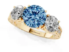 Fancy Blue Round Cut Diamond Three-Stone Engagement Ring Set in Yellow gold with Milgrain Pavé Band