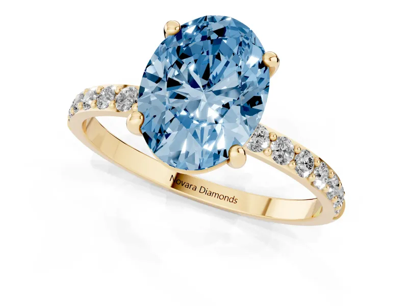 Fancy Blue Oval Cut Diamond Solitaire Ring Set in Yellow gold with Round Pavé Band and Prong Setting
