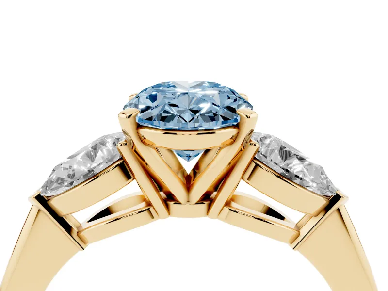 Fancy Blue Three-Stone Oval Cut Diamond Ring Set in Yellow gold with Pear Side Stones and Prong Setting