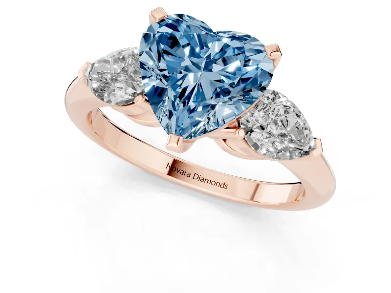 Fancy Blue Three-Stone Heart Cut Diamond Ring Set in Rose gold with Pear Side Stones and Prong Setting