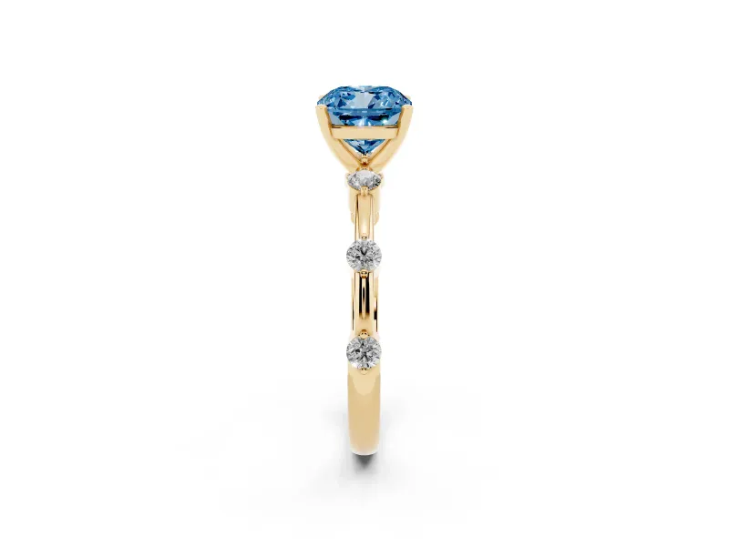 Fancy Blue Cushion Cut Diamond Solitaire Ring Set in Yellow gold with Bezel Set Side Stones and Prong Setting