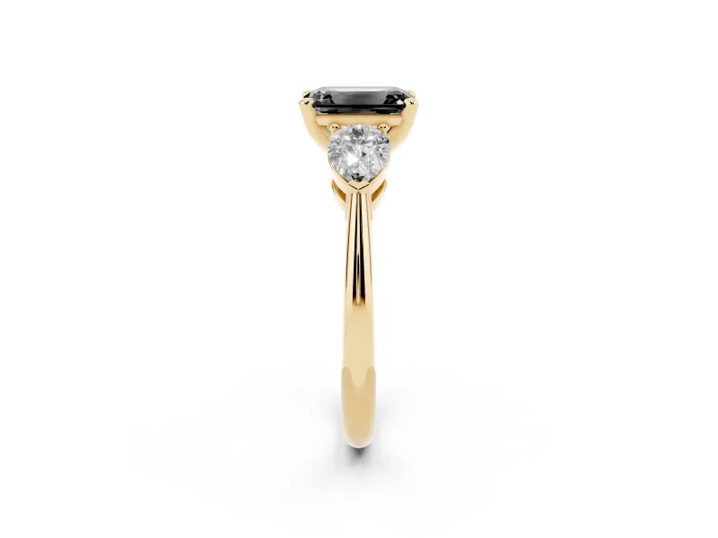 Fancy Black Three-Stone Emerald Cut Diamond Ring Set in Yellow gold with Pear Side Stones and Prong Setting