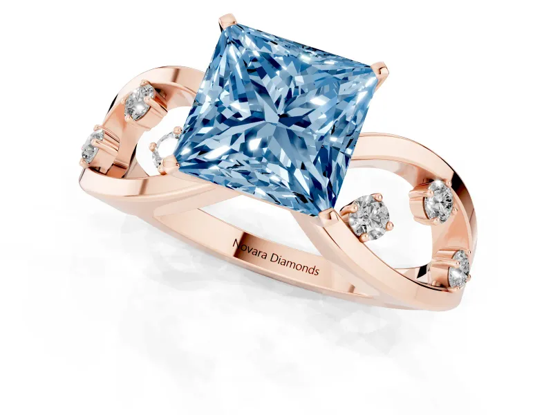 Fancy Blue Princess Cut Diamond Solitaire Ring Set in Rose gold with Side Stones on Criss-Cross Band and Prong Setting