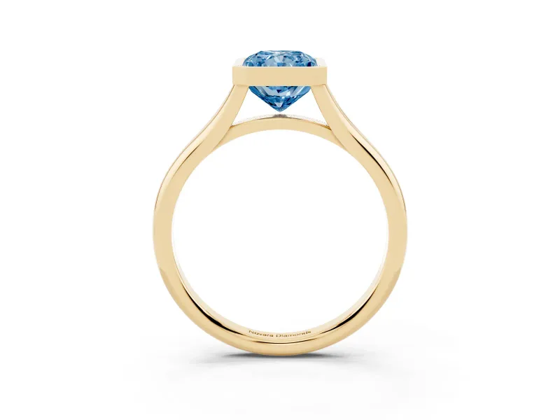 Fancy Blue Bezel Set Radiant Cut Diamond Solitaire Ring Set in Yellow gold with Tapered Band