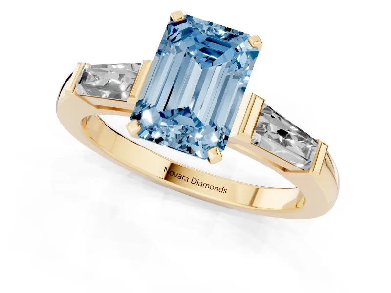 Fancy Blue Emerald Cut Diamond Solitaire Ring Set in Yellow gold with Tapered Baguette Side Stones and Prong Setting