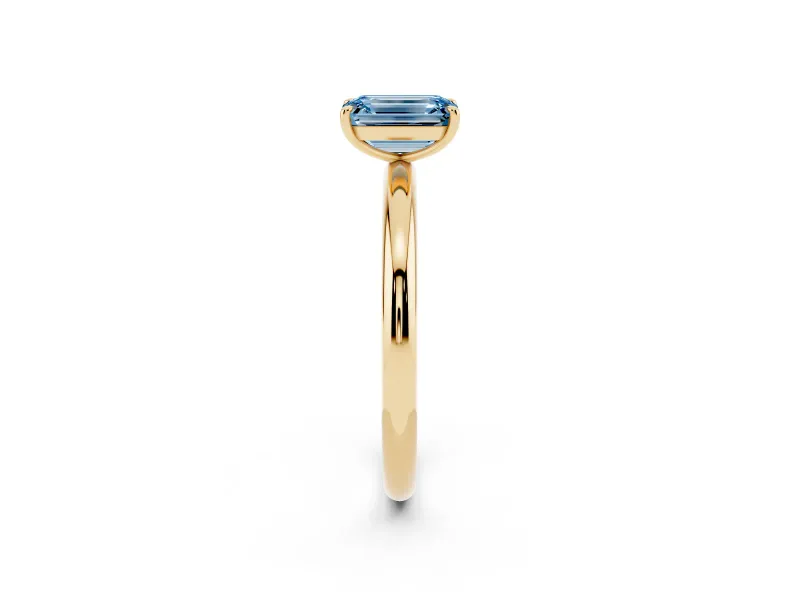 Fancy Blue Emerald Cut Diamond Solitaire Ring Set in Yellow gold with Prong Setting on a Polished Plain Band