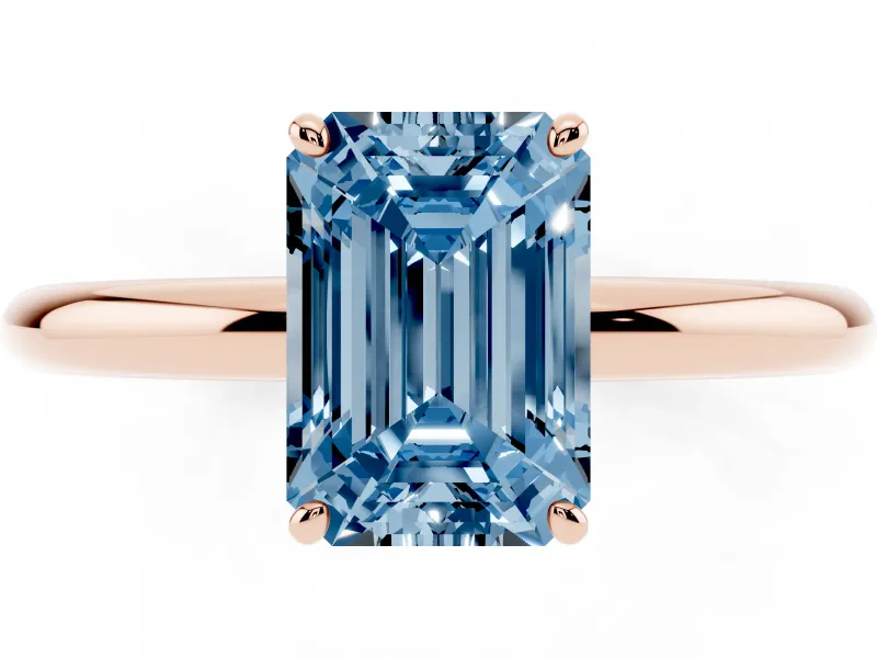 Fancy Blue Emerald Cut Diamond Solitaire Ring Set in Rose gold with Prong Setting on a Polished Plain Band