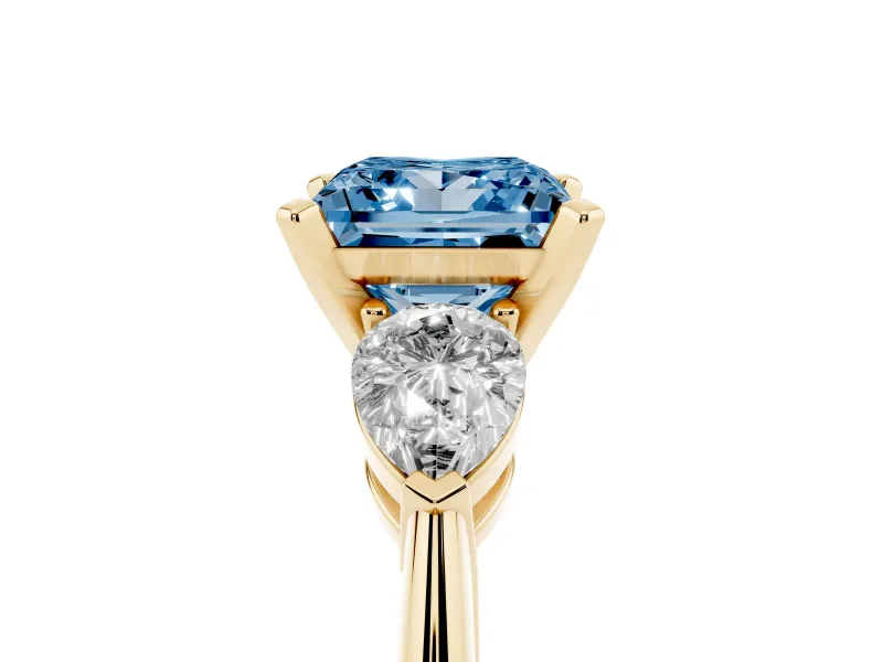 Fancy Blue Three-Stone Princess Cut Diamond Ring Set in Yellow gold with Pear Side Stones and Prong Setting