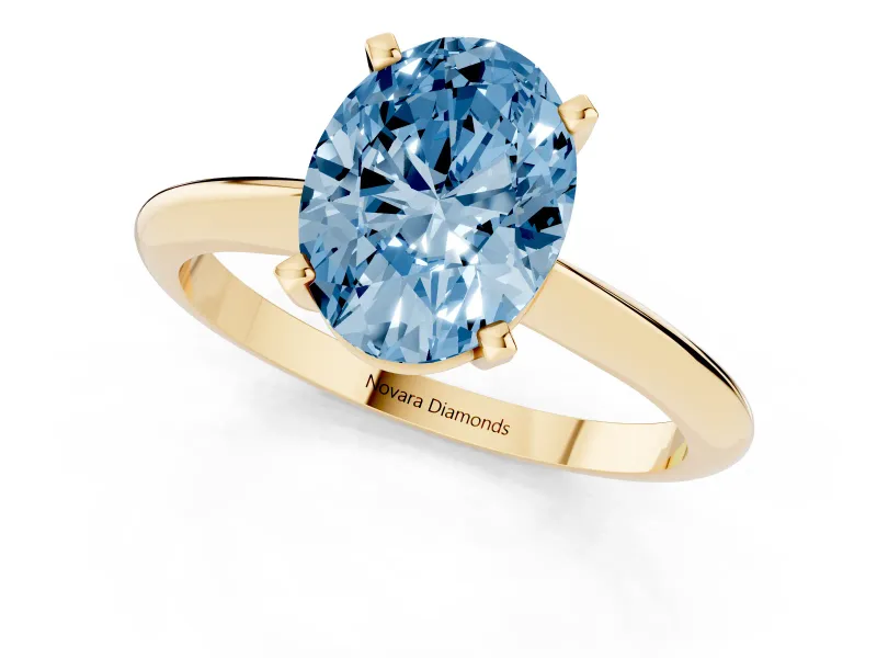 Fancy Blue Oval Cut Diamond Solitaire Ring Set in Yellow gold with Prong Setting on a Plain Round Band