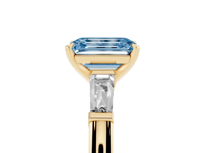 Fancy Blue Emerald Cut Diamond Solitaire Ring Set in Yellow gold with Tapered Baguette Side Stones and Prong Setting