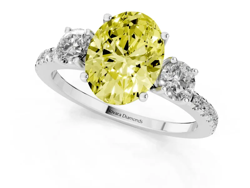Fancy Yellow Oval Cut Diamond Three-Stone Ring Set in Platinum with Pavé Band and Graduated Sides
