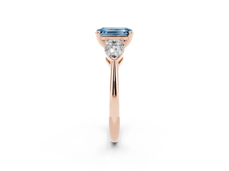 Fancy Blue Three-Stone Emerald Cut Diamond Ring Set in Rose gold with Pear Side Stones and Prong Setting