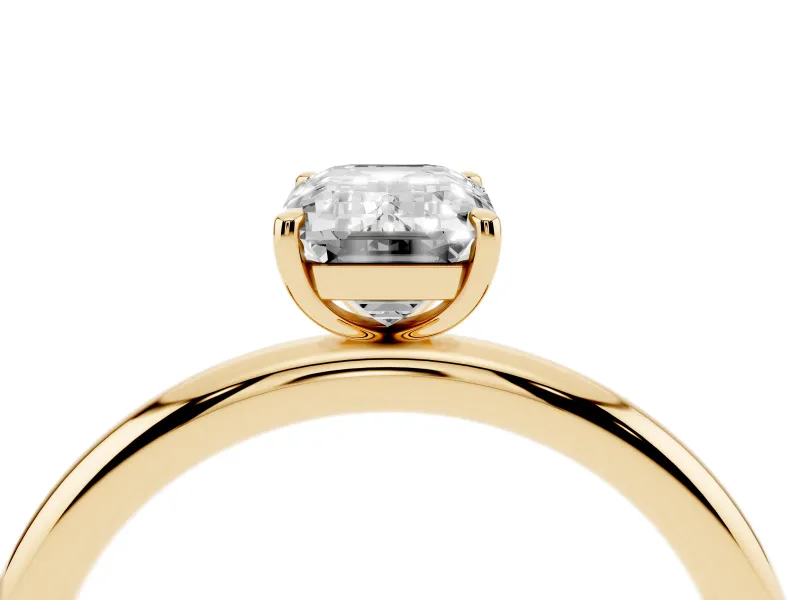Emerald Cut Diamond Solitaire Ring Set in Yellow gold with Prong Setting on a Polished Plain Band