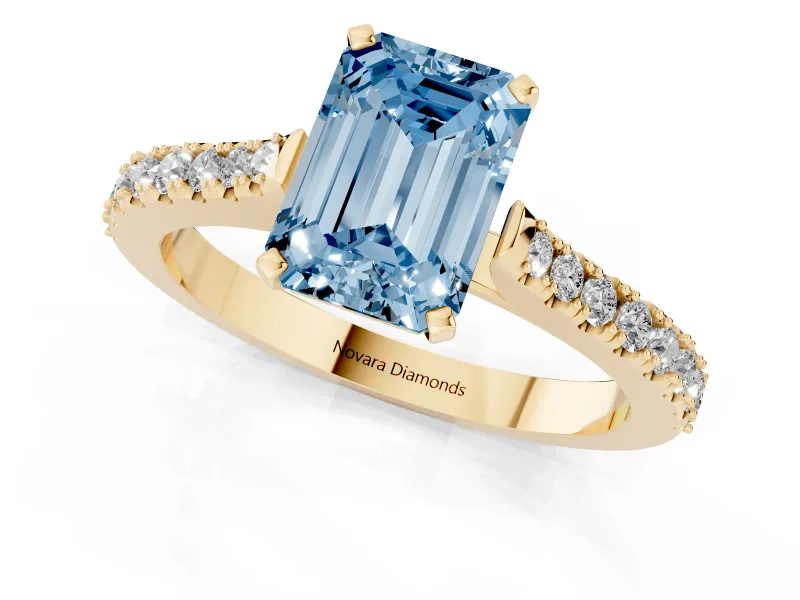 Fancy Blue Emerald Cut Diamond Solitaire Engagement Ring Set in Yellow gold with Delicate Pavé Band and Prong Setting