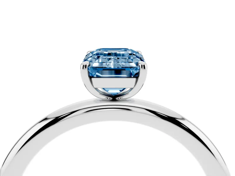 Fancy Blue Emerald Cut Diamond Solitaire Ring Set in White gold with Prong Setting on a Polished Plain Band