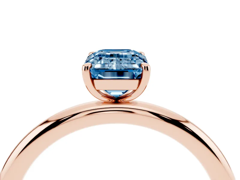 Fancy Blue Emerald Cut Diamond Solitaire Ring Set in Rose gold with Prong Setting on a Polished Plain Band
