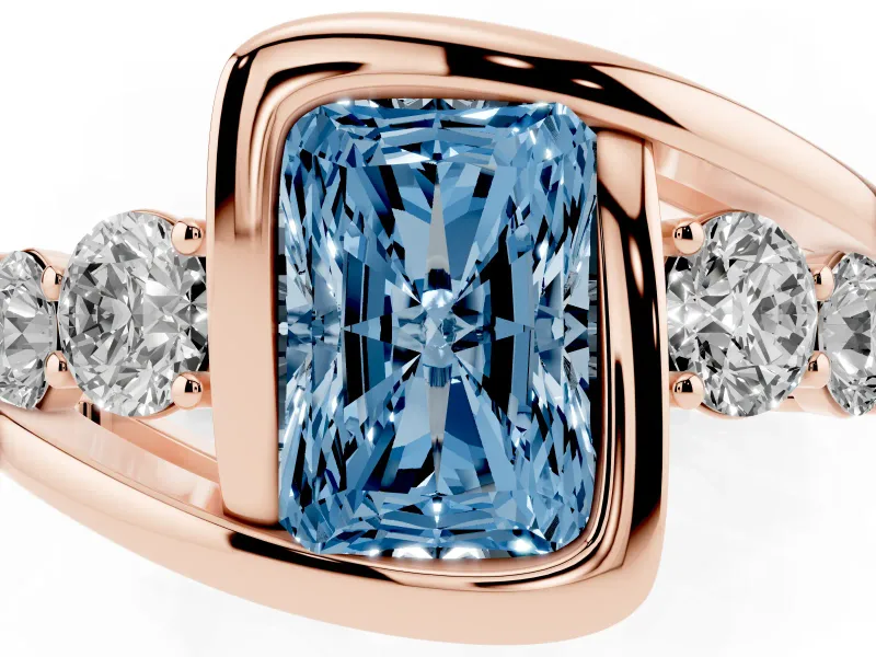 Fancy Blue Radiant Cut Diamond Bezel Bypass Ring Set in Rose gold with Round Accents