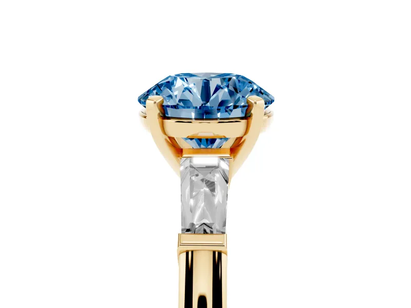 Fancy Blue Round Cut Diamond Solitaire Ring Set in Yellow gold with Tapered Baguette Side Stones and Prong Setting