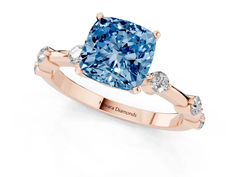 Fancy Blue Cushion Cut Diamond Solitaire Ring Set in Rose gold with Bezel Set Side Stones and Prong Setting