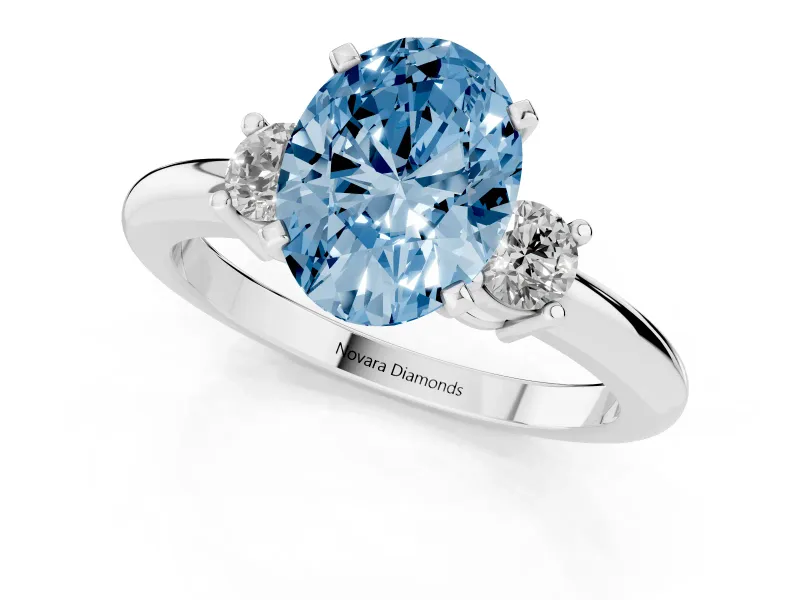 Fancy Blue Three-Stone Oval Cut Diamond Ring Set in White gold with Prong Setting and Plain Band