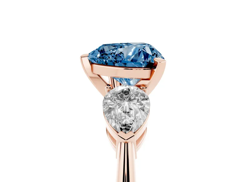 Fancy Blue Three-Stone Heart Cut Diamond Ring Set in Rose gold with Pear Side Stones and Prong Setting