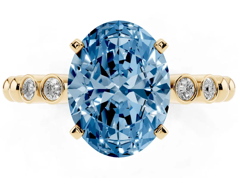 Fancy Blue Oval Cut Diamond Solitaire Engagement Ring Set in Yellow gold with Bezel Accents on Beaded Band