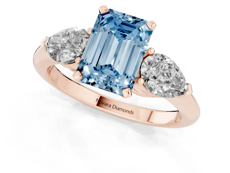 Fancy Blue Three-Stone Emerald Cut Diamond Ring Set in Rose gold with Pear Side Stones and Prong Setting