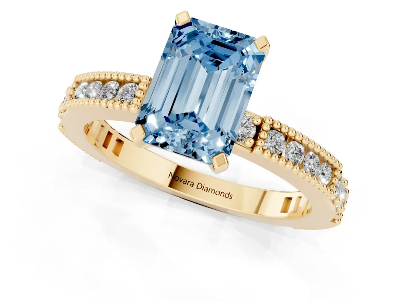 Fancy Blue Emerald Cut Diamond Solitaire Ring Set in Yellow gold with Slim Pavé Band and Prong Setting