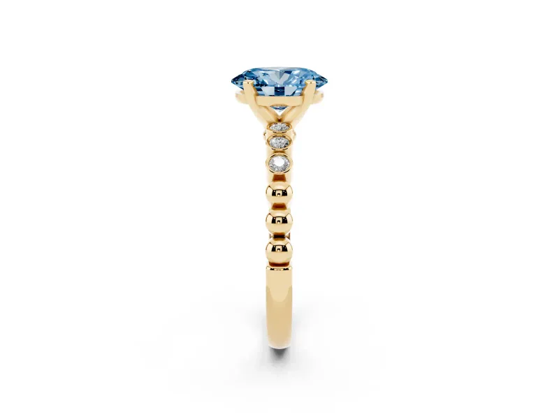 Fancy Blue Oval Cut Diamond Solitaire Engagement Ring Set in Yellow gold with Bezel Accents on Beaded Band