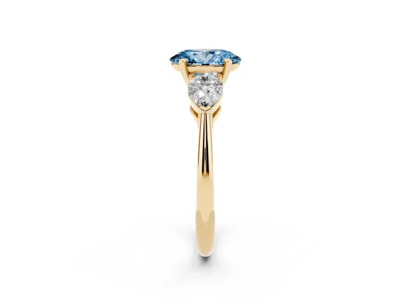 Fancy Blue Three-Stone Oval Cut Diamond Ring Set in Yellow gold with Pear Side Stones and Prong Setting