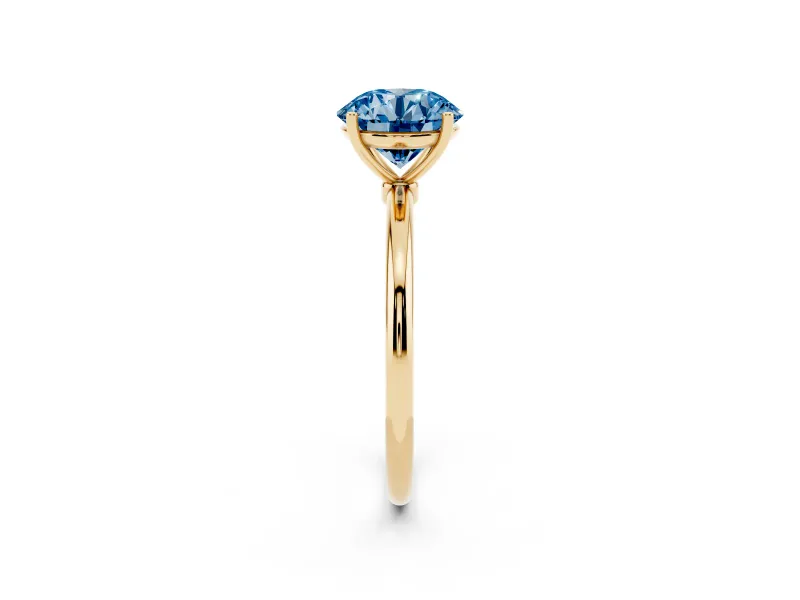 Fancy Blue Round Cut Diamond Solitaire Engagement Ring Set in Yellow gold with Thin Band and Prong Setting