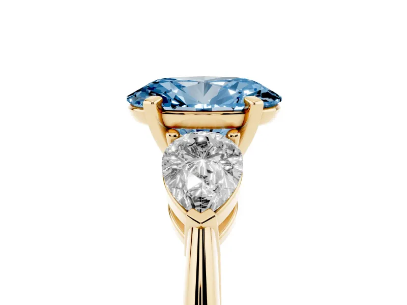 Fancy Blue Three-Stone Oval Cut Diamond Ring Set in Yellow gold with Pear Side Stones and Prong Setting