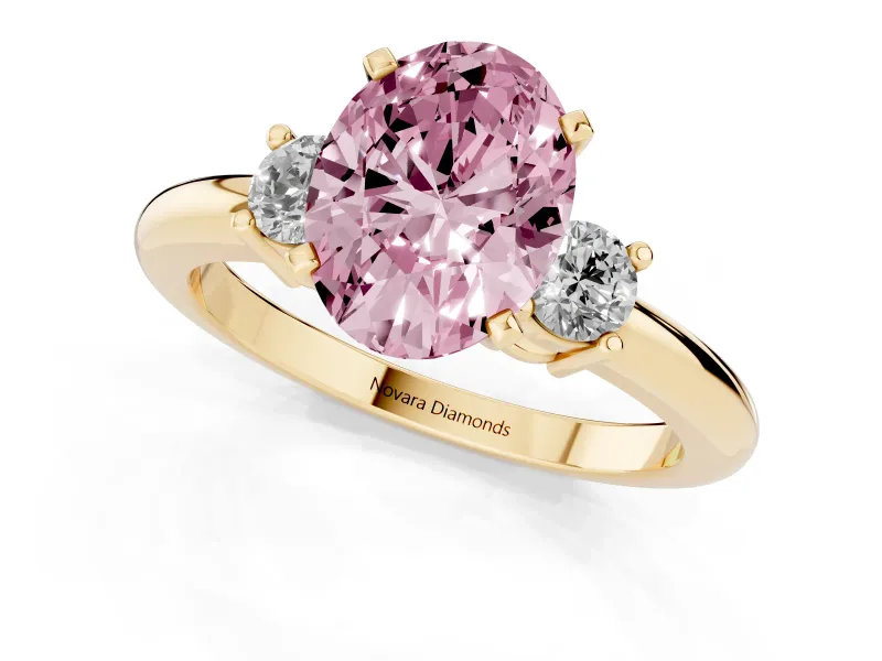 Fancy Pink Three-Stone Oval Cut Diamond Ring Set in Yellow gold with Prong Setting and Plain Band