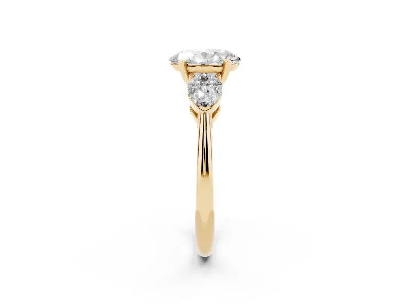 Three-Stone Oval Cut Diamond Ring Set in Yellow gold with Pear Side Stones and Prong Setting