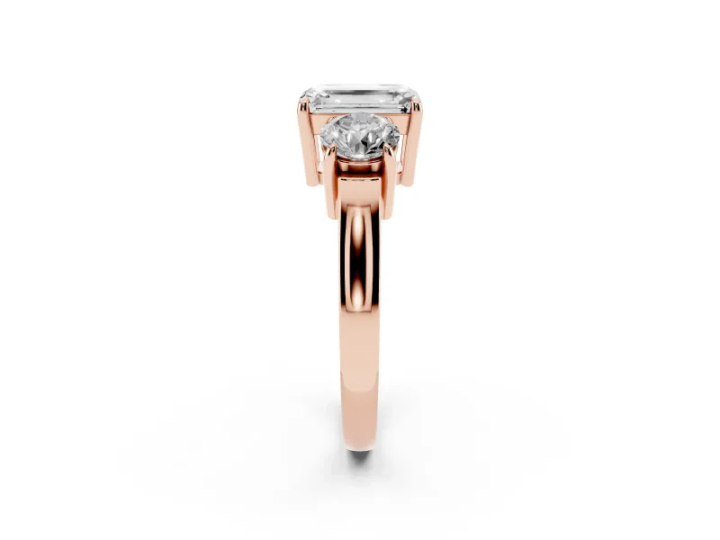Emerald Cut Diamond Three-Stone Ring Set in Rose gold with Round Accent Stones and Plain Band