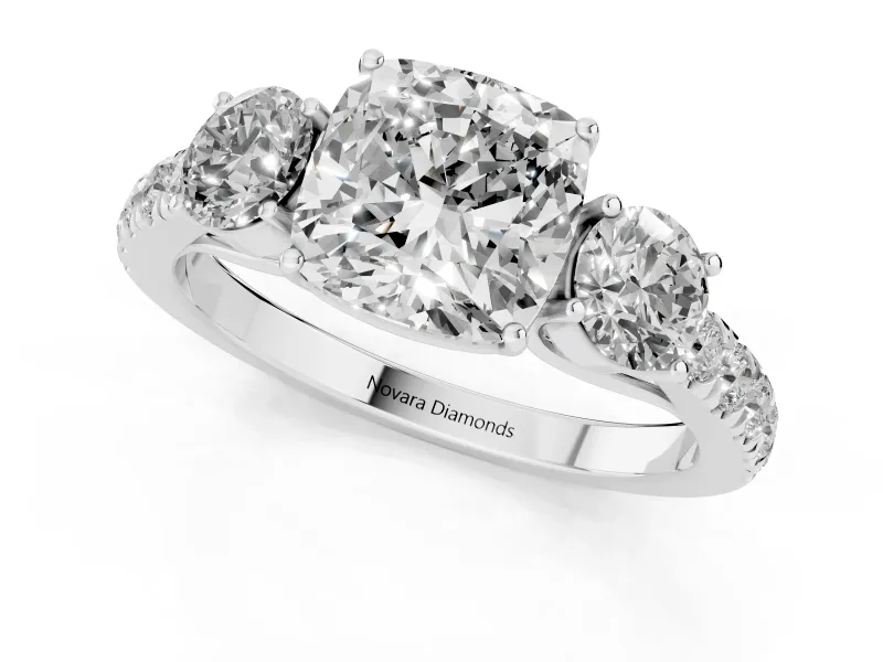 Cushion Cut Diamond Three-Stone Ring Set in Platinum with Round Side Stones and Delicate Pavé Band