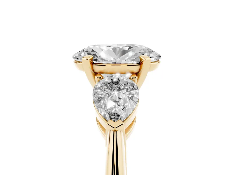 Three-Stone Oval Cut Diamond Ring Set in Yellow gold with Pear Side Stones and Prong Setting
