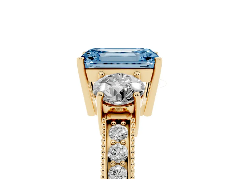 Fancy Blue Emerald Cut Diamond Three-Stone Ring Set in Yellow gold with Round Side Stones and Pavé Band