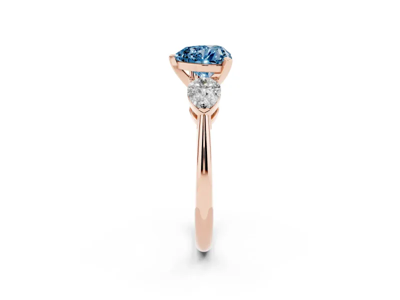 Fancy Blue Three-Stone Heart Cut Diamond Ring Set in Rose gold with Pear Side Stones and Prong Setting